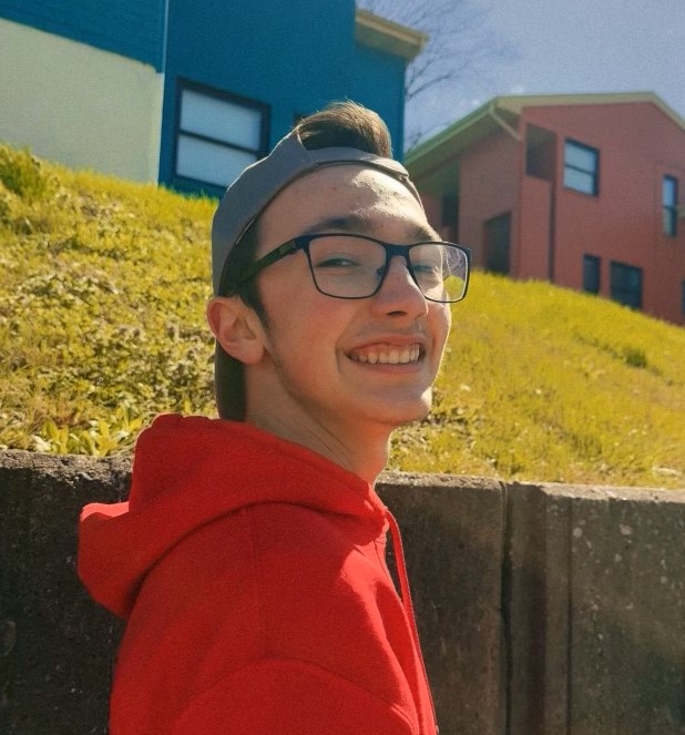 Photo of John LoBuglio smiling while walking along the side walk.