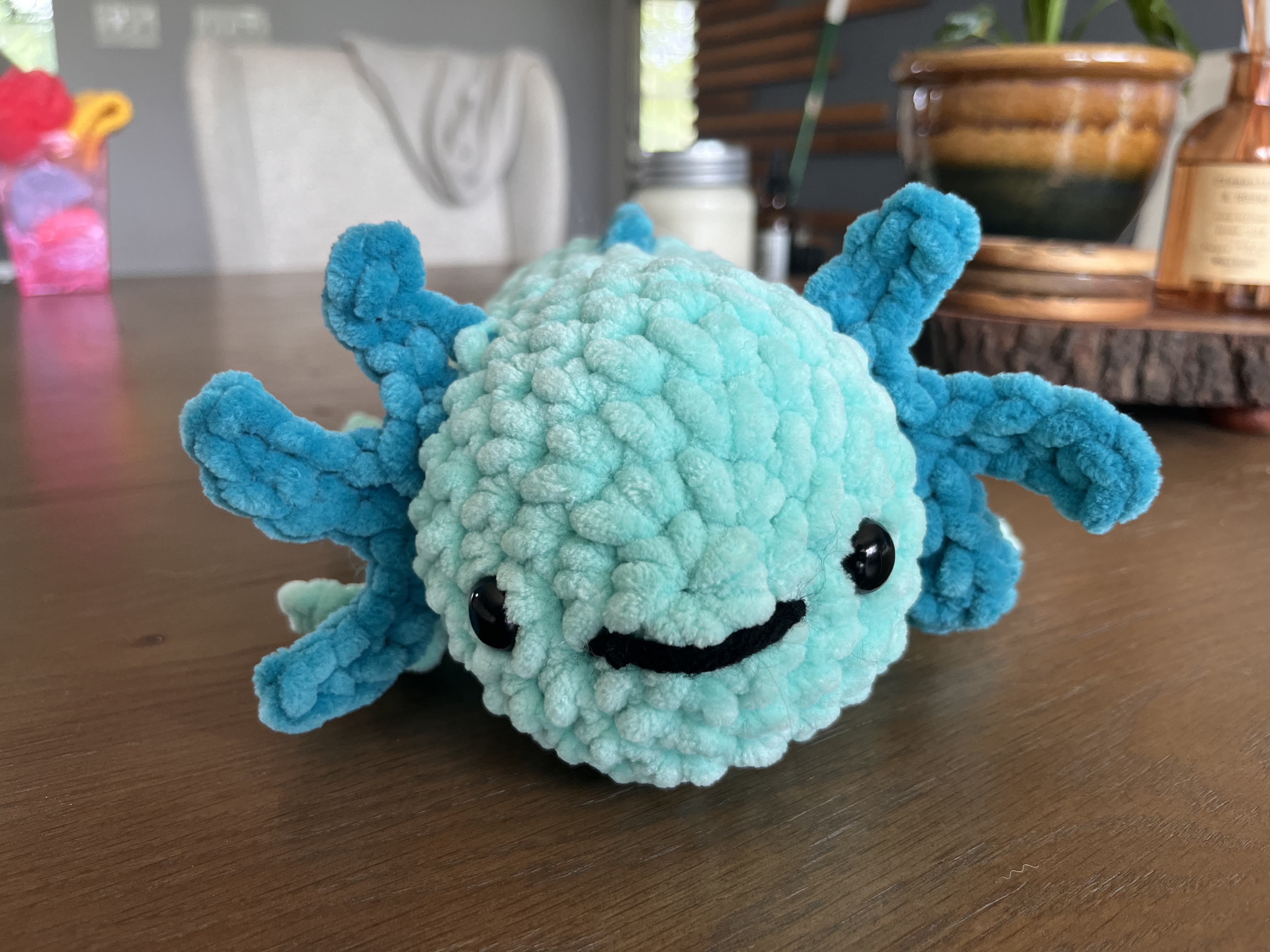 Front facing photo of a blue crocheted axolotl